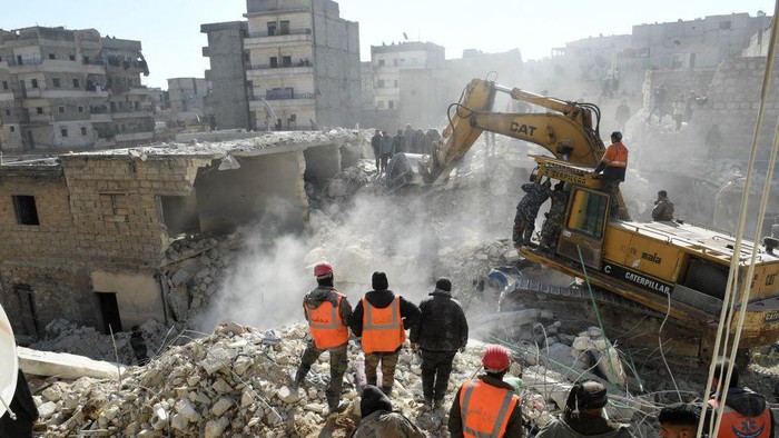 Rescuers sift through the rubble of a destroyed building in the the northern Syrian city of Aleppo, on January 22, 2023. - The building collapsed today, killing at least 16 people including children, authorities and media reported. (Photo by AFP) (Photo by -/AFP via Getty Images)