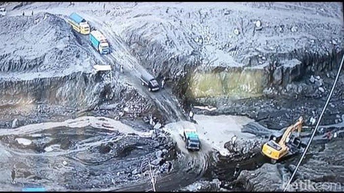 Petugas BPBD Lumajang dibantu para penambang membersihkan batu batu yang menutup jalur alternatif Lumajang-Malang