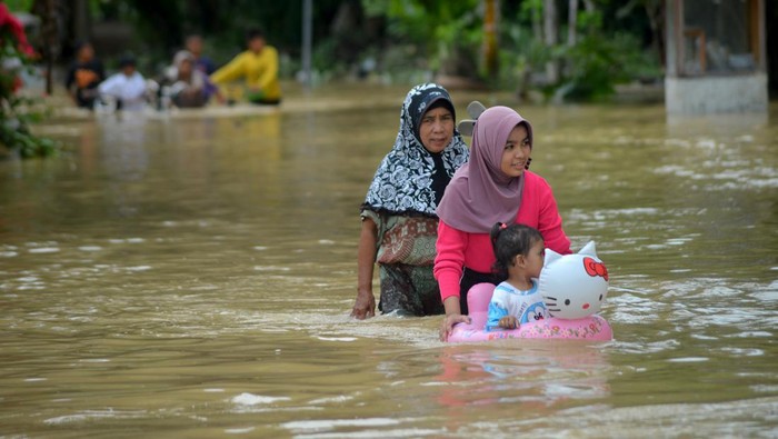Warga melintasi banjir di Korong Kasai, Nagari Tapakis, Kabupaten Padang Pariaman, Sumatera Barat, Selasa (24/1/2023). Berdasarkan data BPBD Padang Pariaman, intensitas hujan tinggi sejak Senin (23/1/2023) menyebabkan bencana banjir dan longsor di sejumlah titik di kabupaten itu, dengan korban meninggal dua orang dan sekitar 750 kepala keluarga mengungsi.  ANTARA FOTO/Iggoy el Fitra/aww.