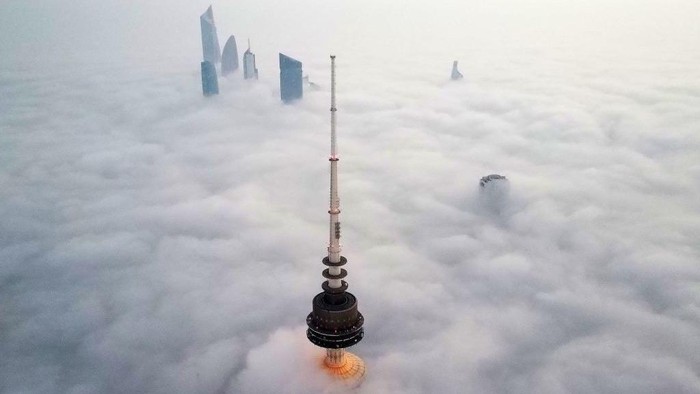 Potret Gedung Tinggi Kuwait Menembus 'Awan' Bak Istana Langit This aerial view shows Kuwait City in a heavy fog, on January 22, 2023. (Photo by YASSER AL-ZAYYAT / AFP) (Photo by YASSER AL-ZAYYAT/AFP via Getty Images)