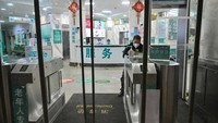 Gabungan gambar menunjukkan (atas) foto anggota staf medis yang mengenakan pakaian pelindung di Rumah Sakit Palang Merah Wuhan di Wuhan pada 25 Januari 2020, dan (bawah) pemandangan yang sama di luar Rumah Sakit Palang Merah Wuhan di Wuhan pada 22 Januari 2023.  