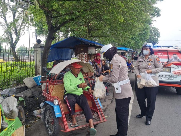 Sejumlah polwan di Jombang membagikan nasi bungkus kepada tukang becak