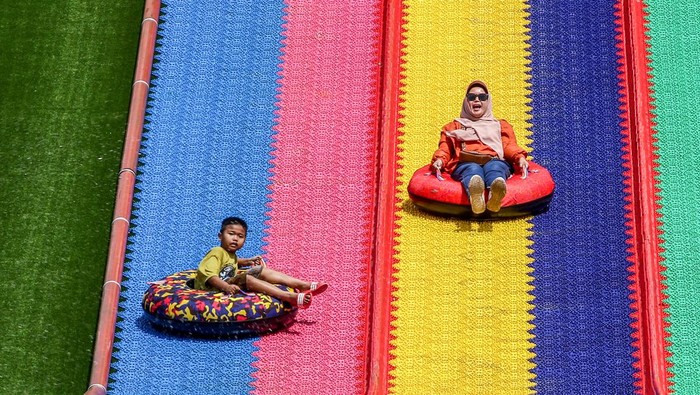 Serunya Meluncur dari Perosotan Pelangi di Taman Bunga Jatinangor BANDUNG, WEST JAVA, INDONESIA - 2023/01/21: A woman is seen enjoying the rainbow slide ride during the Lunar New Year Holiday 2023 in Jatinangor National Flower Park. Jatinangor National Flower Park, which has some attractions rides, and photo spots Instagram-able has become one of the favorite destinations for people to spend the Chinese New Year Holiday 2023 with family. (Photo by Algi Febri Sugita/SOPA Images/LightRocket via Getty Images)
