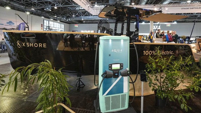 An electric boat is charged while it is on display for sale at the boat show in Duesseldorf, Germany, Monday, Jan. 23, 2023. (AP Photo/Martin Meissner)