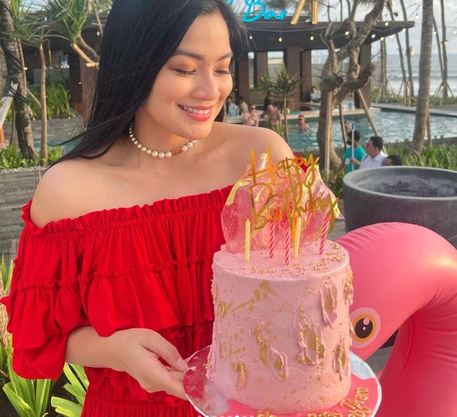 Untuk mempercantik penampilannya Titi Kamal mengenakan kalung mutiara. Sambil memegang kue ulang tahun berwarna merah muda Titi memamerkan senyum manisnya. Foto: Instagram/@titi_kamall