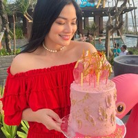 Untuk mempercantik penampilannya Titi Kamal mengenakan kalung mutiara. Sambil memegang kue ulang tahun berwarna merah muda Titi memamerkan senyum manisnya. Foto: Instagram/@titi_kamall