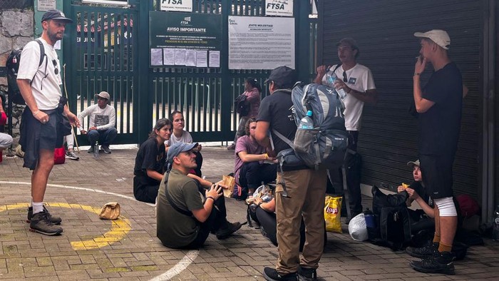 Tourists wait outside the Machu Picchu train station after the railway service was suspended due to damages allegedly caused by protesters in Machu Picchu, Peru, on January 21, 2023. - Peru closed the entrance to the Inca citadel Machu Picchu on Saturday indefinitely, alleging security reasons in the face of protests calling for the resignation of President Dina Boluarte, which already left 46 dead. (Photo by Carolina Paucar / AFP) (Photo by CAROLINA PAUCAR/AFP via Getty Images)