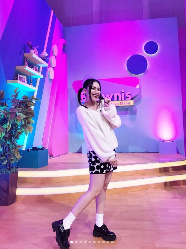 Menjadi salah satu host di acara Brownis, Ayu pun kerap membagikan foto penampilan dirinya bergaya ala wanita Korea. Seperti dalam foto yang satu ini, ia tampak memadukan sweater putih dengan rok mini bermotif bunga dan sepasang sepatu hitam yang dilengkapi kaos kaki putih. Foto: Instagram/@ayutingting92