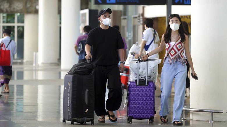 Bali Kembali Sambut Ratusan Pelancong Asal China Chinese tourists arrive at Ngurah Rai international airport in Bali, Indonesia on Sunday, Jan. 22, 2023. A direct flight from China landed in Indonesias resort island of Bali for the first time on Sunday in nearly three years after the route was cancelled due to the pandemic. (AP Photo/Firdia Lisnawati)