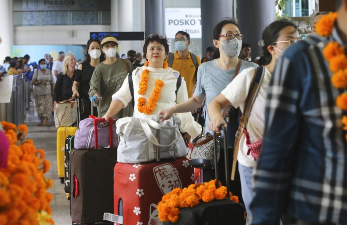 Chinese tourists arrive at Ngurah Rai international airport in Bali, Indonesia on Sunday, Jan. 22, 2023. A direct flight from China landed in Indonesias resort island of Bali for the first time on Sunday in nearly three years after the route was cancelled due to the pandemic.  (AP Photo/Firdia Lisnawati)