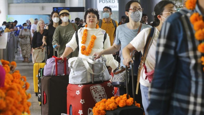 Chinese tourists arrive at Ngurah Rai international airport in Bali, Indonesia on Sunday, Jan. 22, 2023. A direct flight from China landed in Indonesias resort island of Bali for the first time on Sunday in nearly three years after the route was cancelled due to the pandemic.  (AP Photo/Firdia Lisnawati)