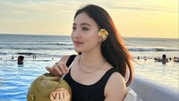 Liburan di Bali terasa tak lengkap tanpa menikmati pemandangan pantai. Natasha pun tak lupa memesan minuman kelapa batok. Slurpp!