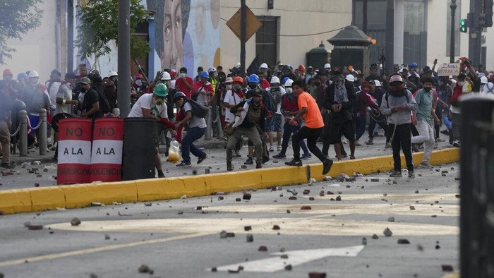 Anti-government protesters clash with police in Lima, Peru, Tuesday, Jan. 24, 2023. Protesters are seeking the resignation of President Dina Boluarte, the release from prison of ousted President Pedro Castillo, immediate elections and justice for demonstrators killed in clashes with police. (AP Photo/Martin Mejia)