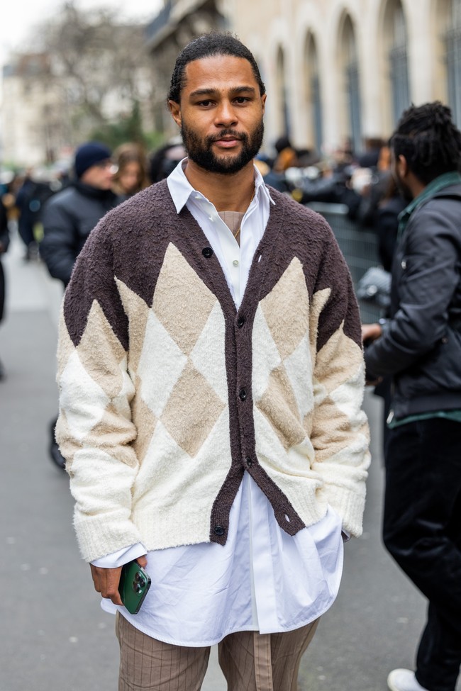 Kali ini, kombinasi kemeja biru dan cardigan oversized kecoklatan menemani penampilan Serge Gnabry. Untuk bawahan, ia memilih celana coklat bermotif garis.  (Foto: Christian Vierig/Getty Images)