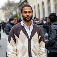 Kali ini, kombinasi kemeja biru dan cardigan oversized kecoklatan menemani penampilan Serge Gnabry. Untuk bawahan, ia memilih celana coklat bermotif garis.  (Foto: Christian Vierig/Getty Images)