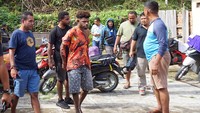Petugas kepolisian berpakaian preman menggiring tersangka kasus pembakaran seorang perempuan karena isu penculikan anak, Fery Tabakore (ketiga kiri), di Kota Sorong, Papua Barat Daya, Rabu (25/1/2023).