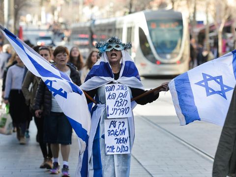 A woman holding Israeli national flags protests on Jerusalem's Jaffa Street.On Thursday, February 6, 2020, in Jerusalem, Israel. (Photo by Artur Widak/NurPhoto via Getty Images)