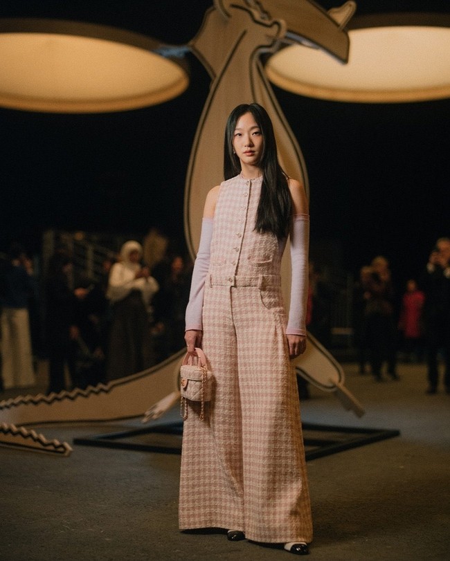 Busana rancangan Creative Director Chanel, Virginie Viard itu dipadukannya dengan manset berwarna lilac yang senada. Foto: Getty Images