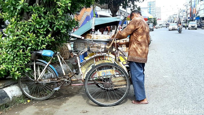 Kosim joki becak Pasar Baru Karawang sedang menata barang muatan.