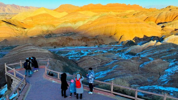 Para pengunjung berswafoto dengan latar belakang keindahan Danxia Scenic. Dapat diketahui, Lapisan tanah yang berwarna-warni di gunung ini diperkirakan terbentuk dari letusan gunung berapi bawah laut yang sudah terjadi jutaan tahun silam. 