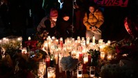 Sejumlah orang memberikan penghormatan kepada korban penembakan massal di California.