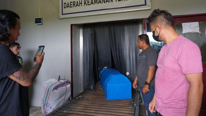Petugas mengangkat peti jenazah korban isu penculikan anak di kargo bandara DEO Kota Sorong, Papua Barat Daya, Rabu (25/1/2023). Pemerintah Kota Sorong melepas jenazah dan memberikan santunan kepada keluarga korban perempuan yang dibakar warga akibat isu penculikan anak menuju Kota Bau-Bau, Sulawesi Tenggara.