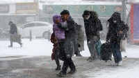 Penumpang melewati salju tebal menuju stasiun kereta api di Gwangju, Korea Selatan, 24 Januari 2023.