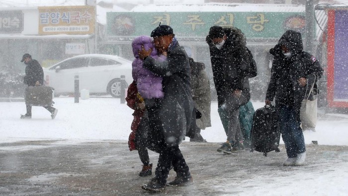 Passengers make their way through a heavy snow to a railway station in Gwangju, South Korea, January 24, 2023.   Yonhap via REUTERS   ATTENTION EDITORS - THIS IMAGE HAS BEEN SUPPLIED BY A THIRD PARTY. SOUTH KOREA OUT. NO RESALES. NO ARCHIVE.