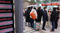 Papan elektronik menunjukkan penerbangan yang dibatalkan akibat badai salju di Bandara Internasional Jeju, Selasa (24/1/2023).