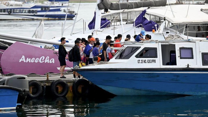 Chinese tourists board a fast boat for their trip from Serangan Island to Lombok Island in Denpasar, on Indonesias resort island of Bali, on January 25, 2023. (Photo by SONNY TUMBELAKA / AFP) (Photo by SONNY TUMBELAKA/AFP via Getty Images)