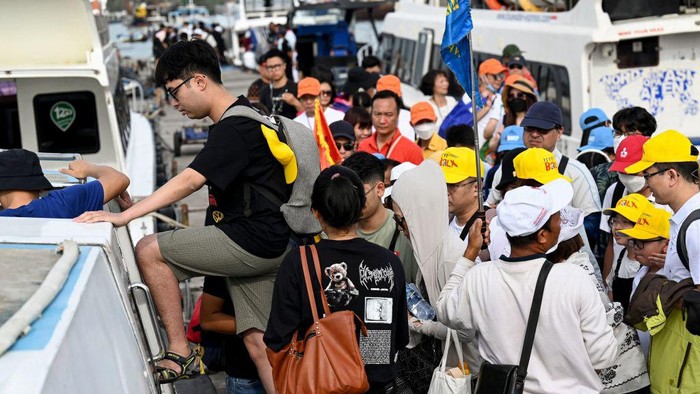 Chinese tourists board a fast boat for their trip from Serangan Island to Lombok Island in Denpasar, on Indonesias resort island of Bali, on January 25, 2023. (Photo by SONNY TUMBELAKA / AFP) (Photo by SONNY TUMBELAKA/AFP via Getty Images)