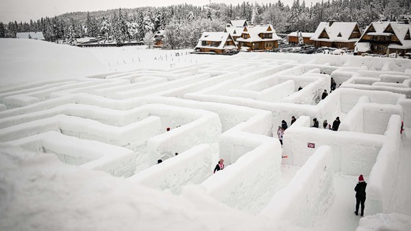 Orang-orang mencoba mencari jalan keluar di labirin Snowlandia Winter Theme Park, Zakopane, Polandia, Sabtu (21/1/2023).  