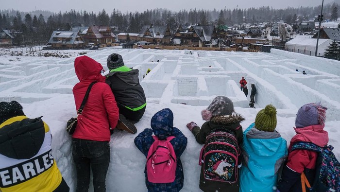 Sensasi Berkelana di Labirin Salju Terbesar Dunia ZAKOPANE, POLAND Γ’ JANUARY 17 : People enjoy ice sculptures at the complex where the biggest snow maze in the world is located in Zakopane, Poland, January 17, 2022. The snow maze idea was created for the first time in the winter season of 2015/2016 with an area of 2500 square metters and was already consider the biggest snow maze in the world. This season the organization increased the size to 3000 square metters and still keeps the title of the biggest snow maze in the world. Poland recently registered 100 thousand deaths by coronavirus and today marked an increased of 34% in covid-19 cases compared to last week. (Photo by Omar Marques/Anadolu Agency via Getty Images)