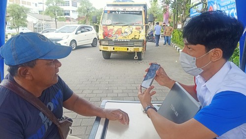 Seorang sopir truk, Tarwiono melakukan proses pendaftaran di Help Desk SPBU Pertamina 54.801.06 di Jalan Bypass Ngurah Rai, Denpasar, Bali, Rabu (25/1/2023)