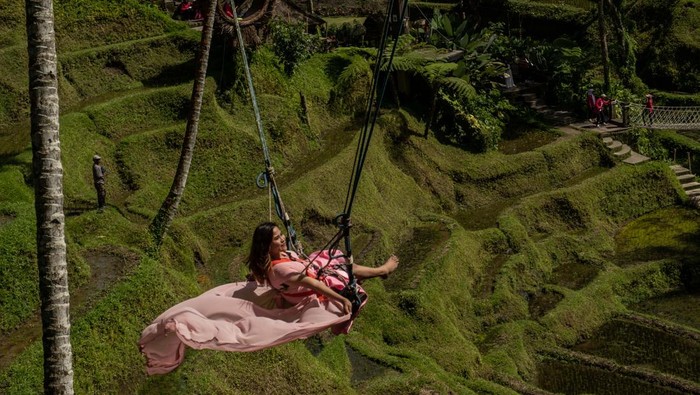 UBUD, BALI, INDONESIA - DECEMBER 8: A foreign tourist uses a swimming pool with a rice terrace in the background on December 8, 2022 in Ubud, Bali, Indonesia. Indonesias parliament voted to pass a law that bans extramarital sex on Tuesday, in a move that critics quoted in local media have said will severely impact the tourism industry. Regions like Bali rely heavily on an influx of foreign tourists to keep their economies afloat, and the new law has raised concerns just as international arrivals start to pick up again post-pandemic. (Photo by Agung Parameswara/Getty Images)