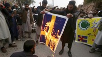 Bendera Swedia tersebut juga dibakar oleh massa aksi yang geram. AP Photo/Muhammad Sajjad