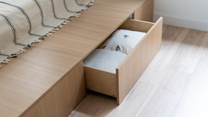 Bedroom interior, wooden bed at modern room. Furniture design with open wood drawer, white pillow decoration object in box. Brown comfortable storage for bedding cushion.