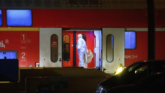 2 Orang Tewas Ditusuk di Kereta Jerman An investigator in a white protective suit works in the regional train that had been driven onto a siding in Neumunster, Germany, Wednesday, Jan. 25, 2023. A knife-wielding man described as a stateless Palestinian has fatally stabbed several people and injured others on a train in northern Germany before being grabbed by passengers and arrested by police, officials said. The motive of Wednesday's attack was not immediately known. (Jonas Walzberg/dpa via AP)