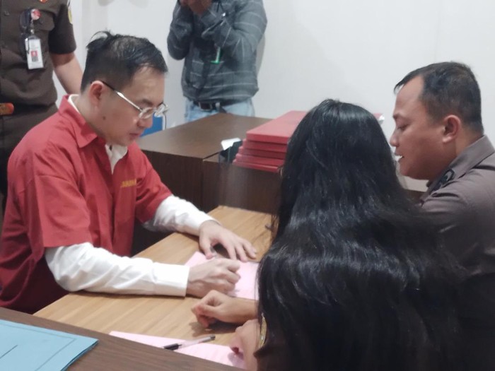 Apin BK menandatangani berkas di Kejari Medan. Foto: Farid Achyadi Siregar/detikSumut