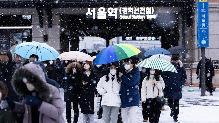 Morning commuters wait for a bus as snow falls in Seoul, South Korea, on Thursday, Jan. 26, 2023. Colder-than-usual weather is set to prevail in North Asia until the end of this month, which may boost heating demand in major energy importers China, Japan and South Korea. Photographer: SeongJoon Cho/Bloomberg via Getty Images