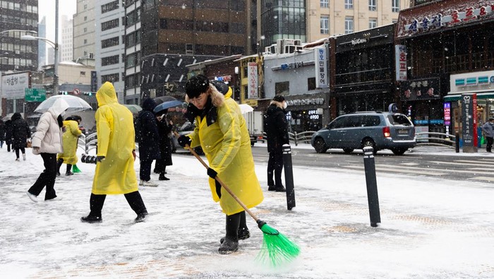 Morning commuters wait for a bus as snow falls in Seoul, South Korea, on Thursday, Jan. 26, 2023. Colder-than-usual weather is set to prevail in North Asia until the end of this month, which may boost heating demand in major energy importers China, Japan and South Korea. Photographer: SeongJoon Cho/Bloomberg via Getty Images