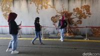 Warga nampak berfoto dengan latar mural 3D di terowongan Kendal. Mural itu dipajang di terowongan Kendal sejak 7 Januari 2023 selama sebulan.
