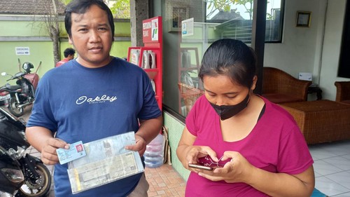 Sopir truk pasir, Adi Kusuma Suroso (kiri) yang tinggal di Mengwi, Badung, usai mengurus pendaftaran aplikasi My Pertamina di SPBU Abiantuwung, Kecamatan Kediri, Kamis (26/1/2023).