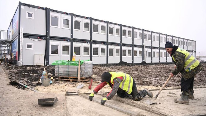 Workers put the finishing touches to a modular housing complex donated by the Polish government as humanitarian aid for the temporary accommodation of evacuees, in Lviv on January 24, 2023, amid the Russian invasion of Ukraine. (Photo by YURIY DYACHYSHYN / AFP) (Photo by YURIY DYACHYSHYN/AFP via Getty Images)