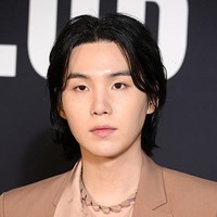 Dalam kesempatan itu, Suga BTS tampil memakai setelan jas bernuansa netral dari koleksi Valentino Spring Summer Ready to Wear Collection 2023. Foto: Getty Images