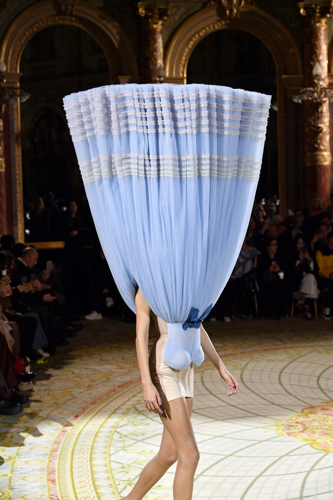 Penasaran bagiamana sang model masih tetap bisa melangkah dengan pasti meski kepala tertutup? Ia dipandu lewat earpiece yang terpasang di telinganya. (Foto: Kristy Sparow/Getty Images)