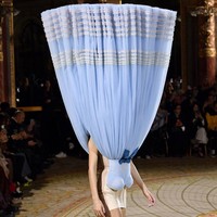 Penasaran bagiamana sang model masih tetap bisa melangkah dengan pasti meski kepala tertutup? Ia dipandu lewat earpiece yang terpasang di telinganya. (Foto: Kristy Sparow/Getty Images)