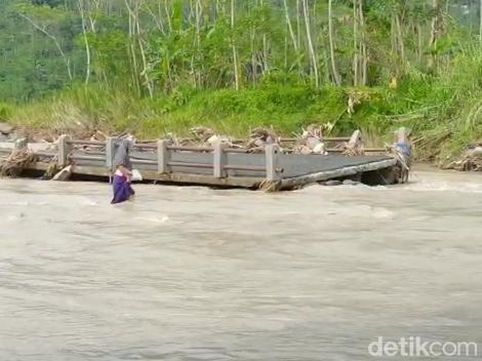 Warga menyeberangi Sungai Kacangan di Banjarnegara yang jembatannya putus, Kamis (26/1/2023).