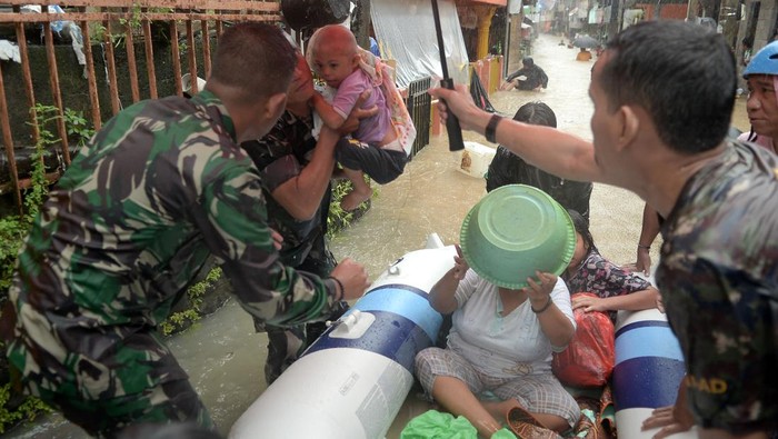 BANJIR DI MANADO Anggota TNI menggendong seorang anak yang dievakuasi dari rumahnya yang terendam banjir di Manado, Sulawesi Utara, Jumat (27/1/2023). Hujan deras sejak dini hari mengakibatkan banjir dan longsor di sejumlah lokasi di kota Manado. ANTARA FOTO/Adwit B Pramono/foc.