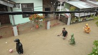 Sejumlah warga berjalan di kompleks perumahan yang terdampak banjir di Manado, Sulawesi Utara, Jumat (27/1/2023).